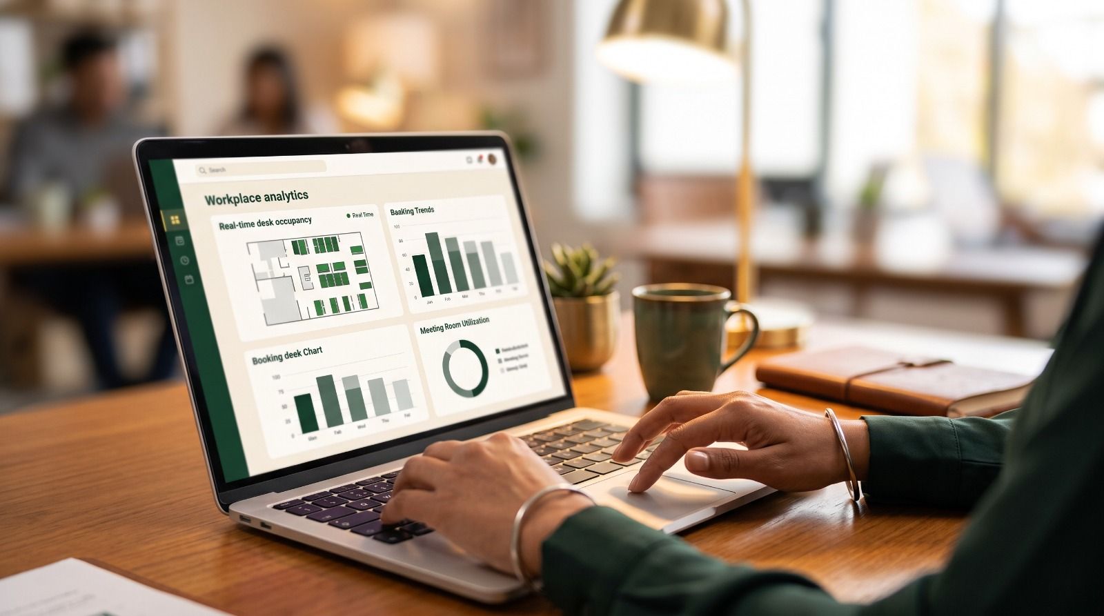 Professional using a laptop displaying a workplace analytics dashboard with desk occupancy, meeting room utilization, and office space optimization reports..jpeg